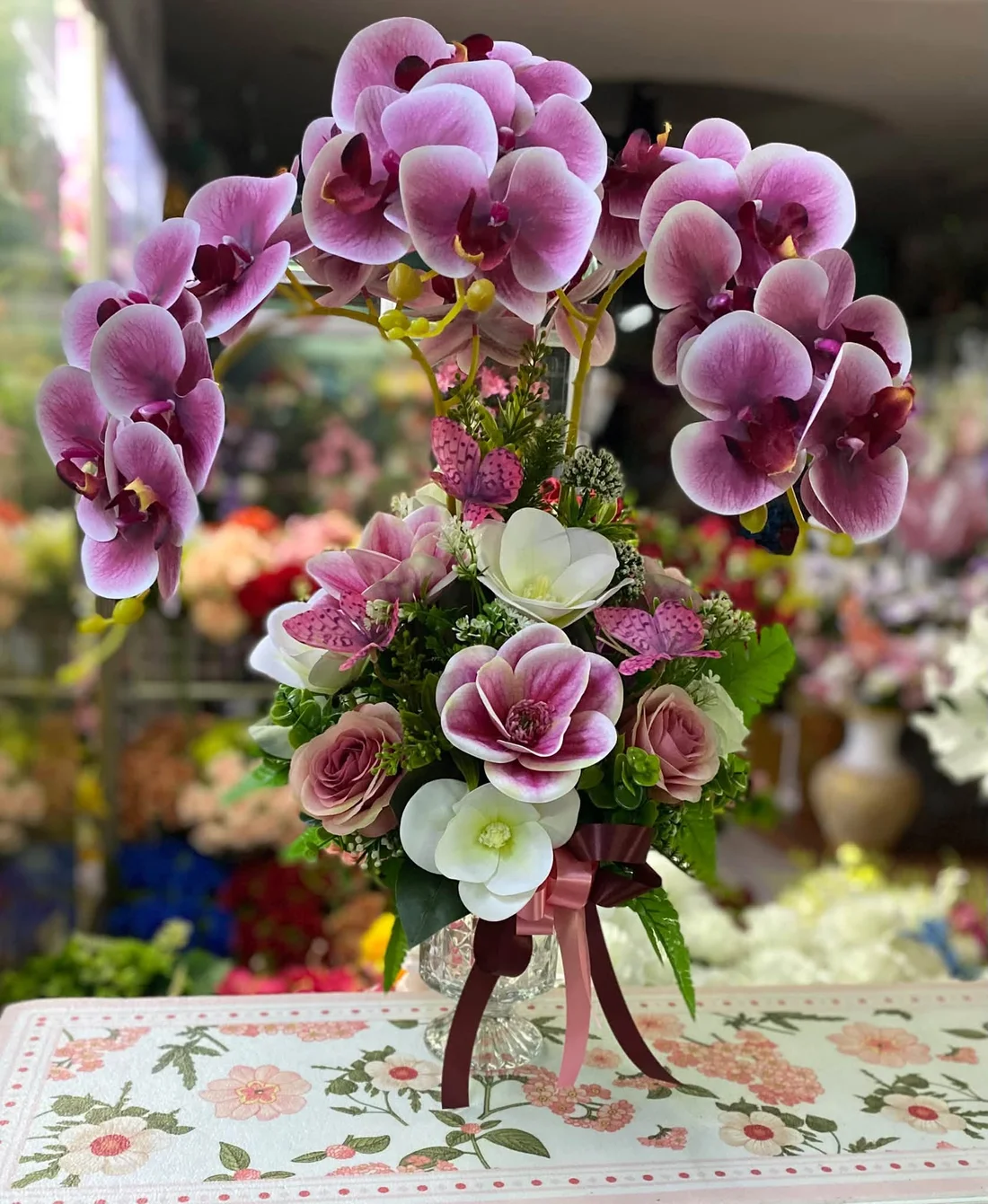 ผลงานจริง J&K Florist: กล้วยไม้ประดิษฐ์สีม่วงจัดในแจกันแก้ว